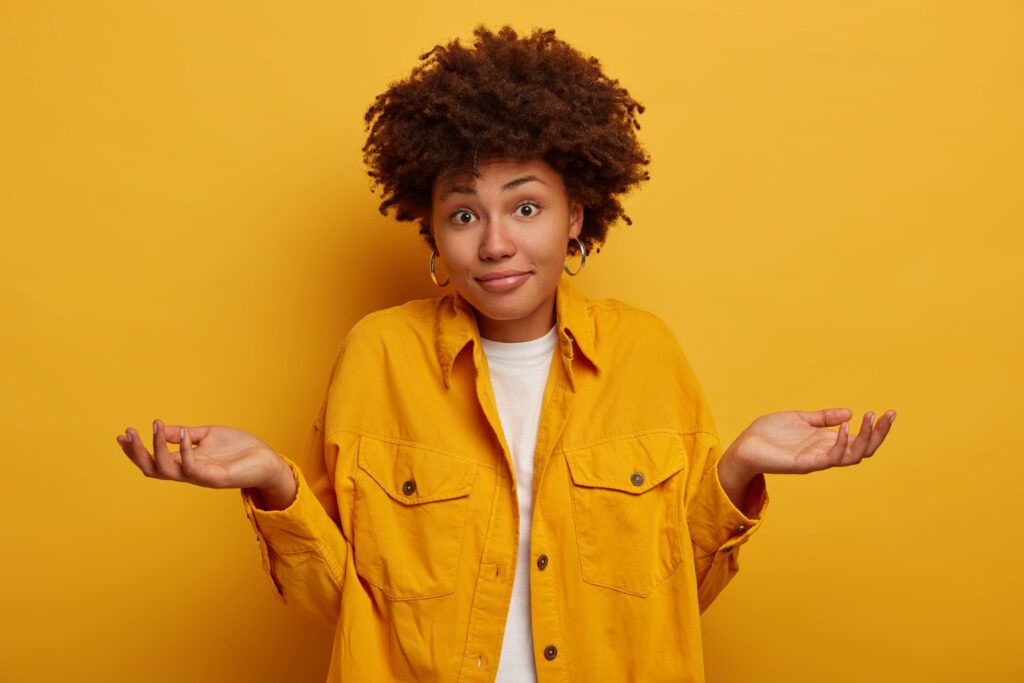 Mulher aparece fazendo um gesto como se estivesse em dúvida, mostrando que o benchmark ajuda a definir qual investimento é o melhor