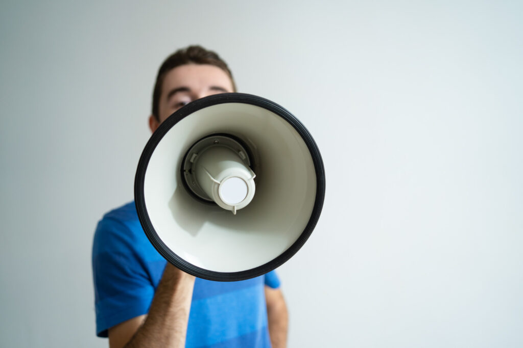 Homem aparece com um megafone gritando para informar um fato relevante