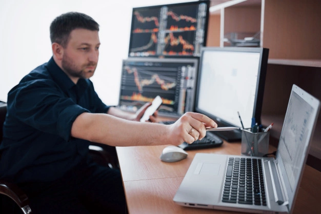 homem analisando tela computadores